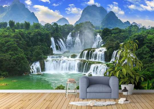 Wall Mural - Cascade in the forest against the sky with fluffy clouds